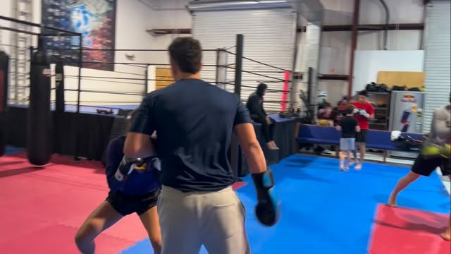 Coach holding boxing mitts at Tru Bloodline MMA gym in Kemah
